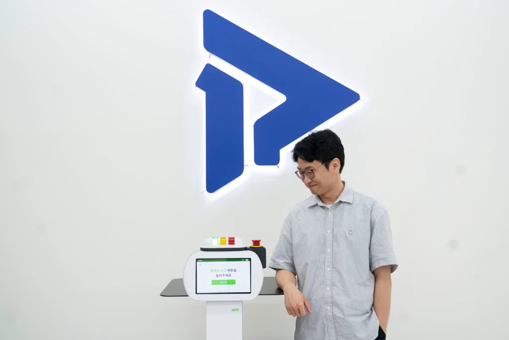 폴라리스쓰리디 이학준 이사가 서빙로봇 이리온과 함께 서있는 모습. 폴라리스쓰리디는 AI 로봇을 통해 사람들의 삶을 더 편하고 풍요롭게 만드는 목표를 가지고 있으며, 이러한 AI 로봇들은 중앙 관제시스템을 통해 효율적으로 운영되어 다양한 서비스 환경에서 활용되고 있다.